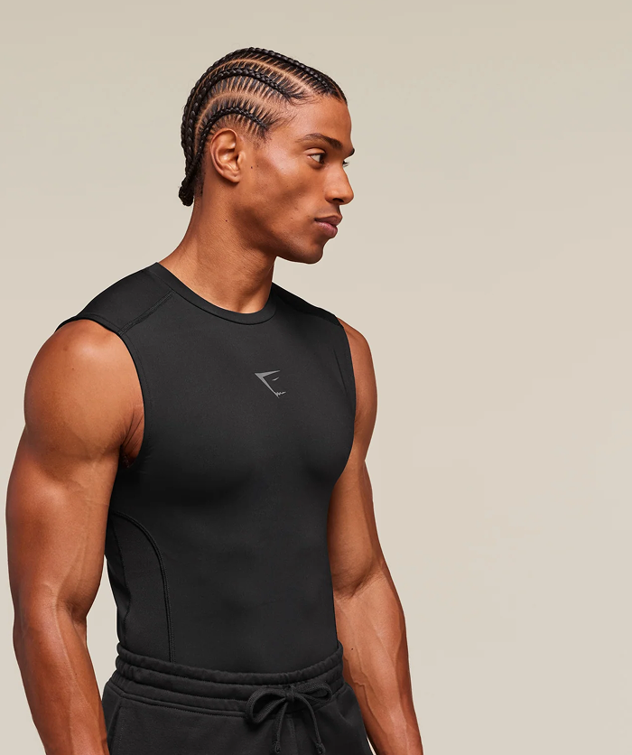 Man wearing a black sleeveless athletic outfit on a beige background